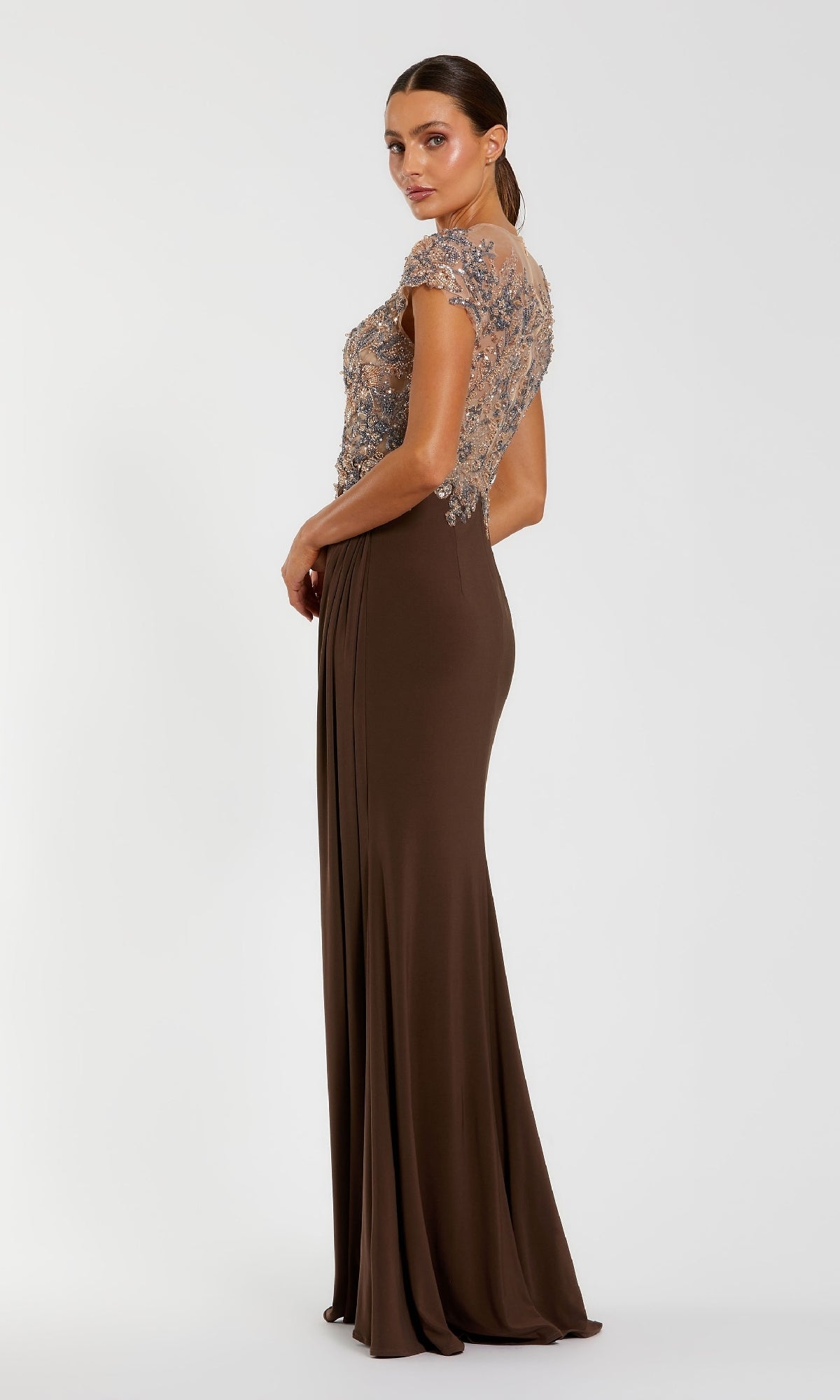 Woman wearing the Mac Duggal 21100 Beaded-Bodice Long Formal Dress in chocolate brown, featuring a sheer embellished bodice and cap sleeves, standing against a plain white background.